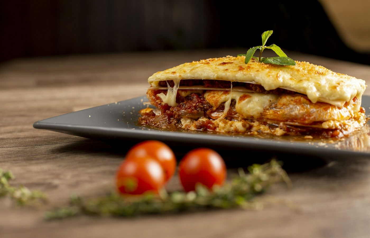 Stück Lasagne auf dunklem Teller