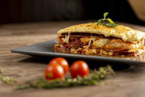 Stück Lasagne auf dunklem Teller